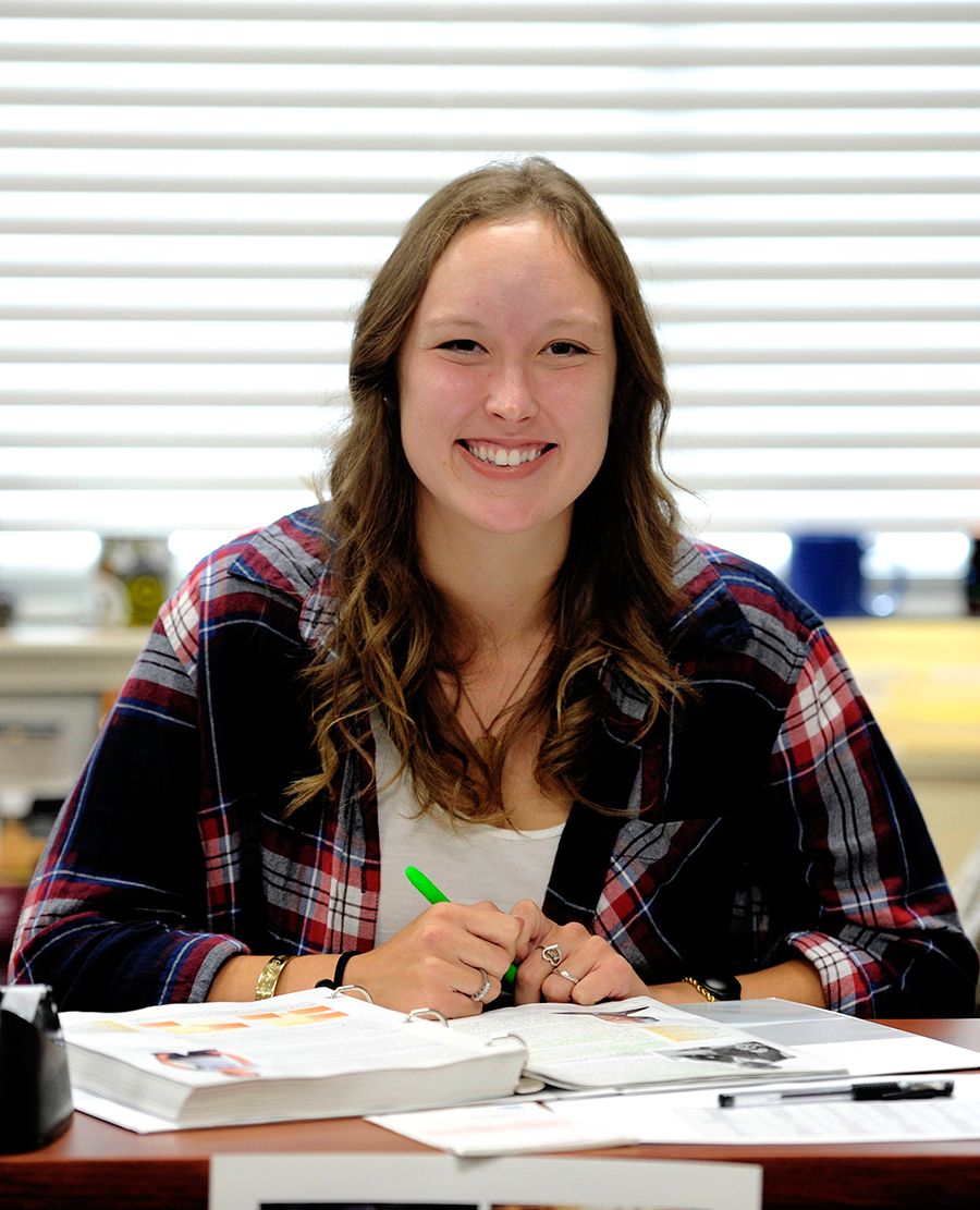 Girl sitting at desk doing homework.