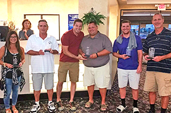 Group of people holding trophies.