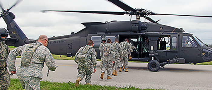 Cadets running towards helicopter in Blackhawk training exercise.