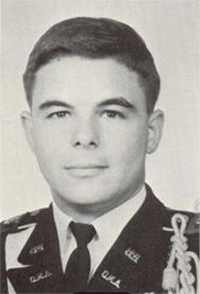 Black and white photo of a man in military uniform, standing confidently with a serious expression.