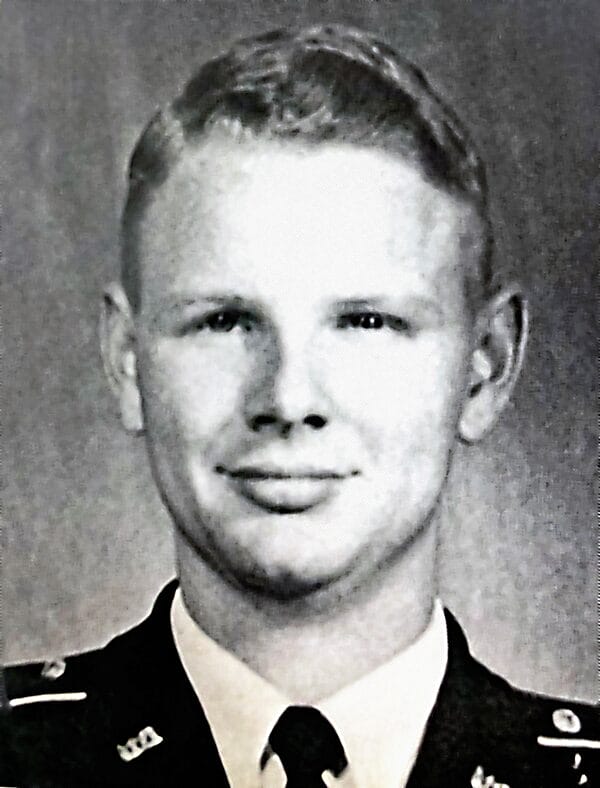 Black and white photo of a young man. He may be wearing a military uniform.