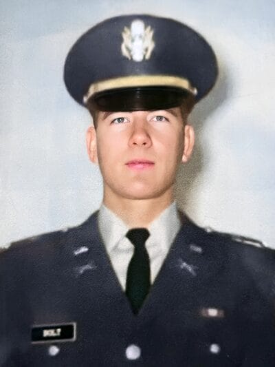 A young man wearing a military uniform stands proudly, showcasing his commitment and service.