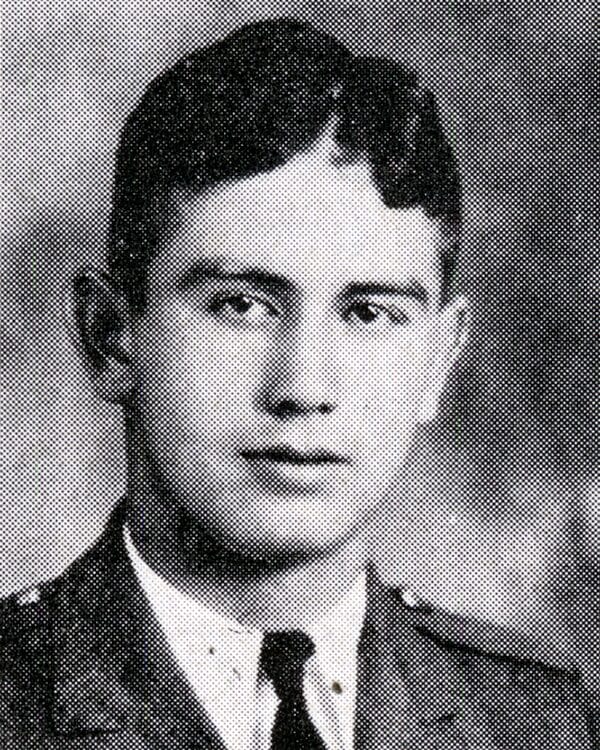 Black and white photo of a young man in military uniform, standing confidently with a serious expression.