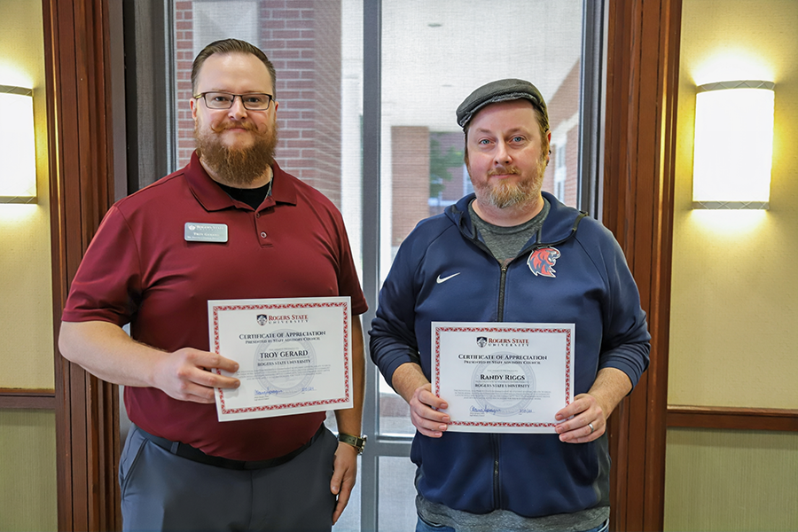 Two men holding certificates.