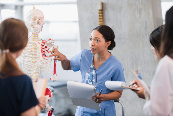Young woman teaches class on human bone structure