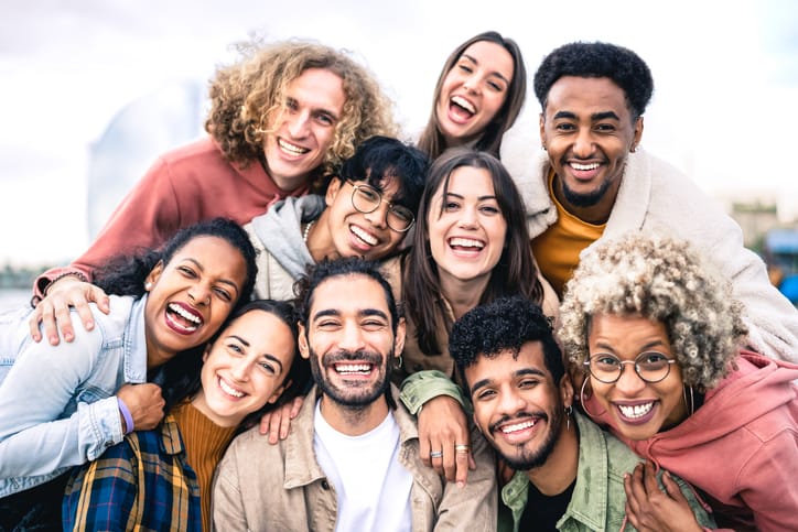 Multi ethnic guys and girls taking selfie outdoors with backlight Happy life style friendship concept on young multicultural people having fun day together in Barcelona Bright vivid filter