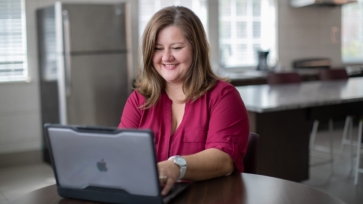 Smiling woman using a laptop on a table