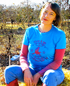 Dr. Jeanetta Calhoun Mish sits on a bail of hay.