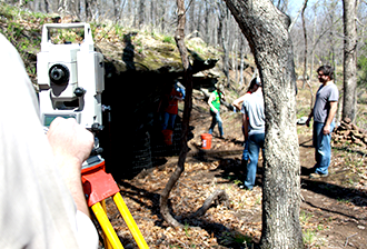 Several men preparing to dig in ground.