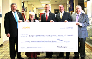 Four men and one woman hold an oversize check for presentation