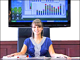 Student sitting a desk surrounded by binders and charts.