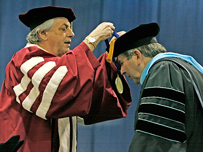 Regent Max Weitzenhoffer places medal on Dr. Rices neck.
