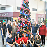 RSU Pryor students pose in front of a Christmas tree decorated with donated gloves.