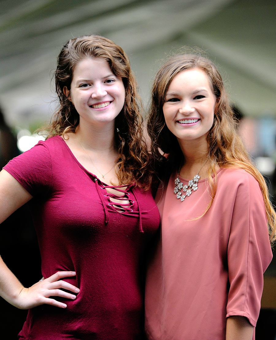 Two girls smiling posing for picture.