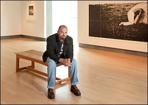 Joshua Meier sitting on a bench in an art studio.