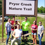 RSU students pose under the Pryor Creek Nature Trail Sign.