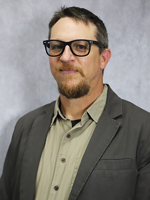 A man wearing glasses and a jacket