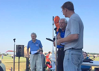 Men making announcement on stage.