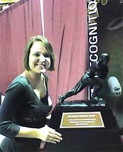 Sara posing with the Heisman Trophy.