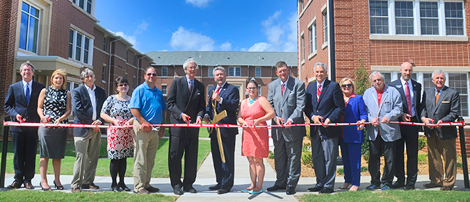 Several people cutting the ribbon in front of UVC.