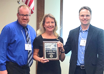 Dr. Carolyn Taylor holding award with Dr. Wood and Dr. Wohlers