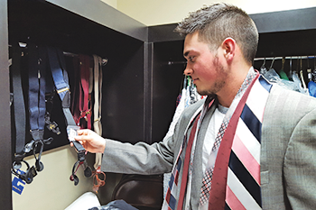 Jesse Dozier, a nursing junior from Kansas, tries on a sports coat and ties as he looks through the new Campus Closet at RSU. 