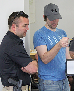 RCSO officer helps an RSU student during the walk through of a simulated crime scene.