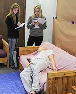 Two RSU students studying the simulated crime scene.