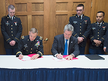 Major General Robbie Asher and President Larry Rice signing agreement.