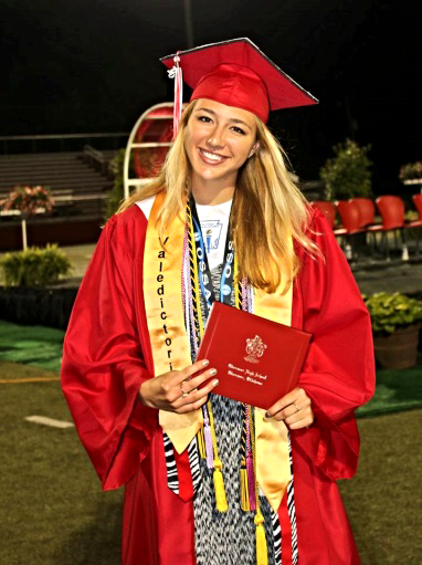 Bailey Steckline dressed in cap and gown holding diploma.