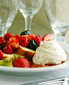 Dessert plate with mixed berries and whipped cream.