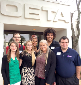 Students standing under the OETA sign.