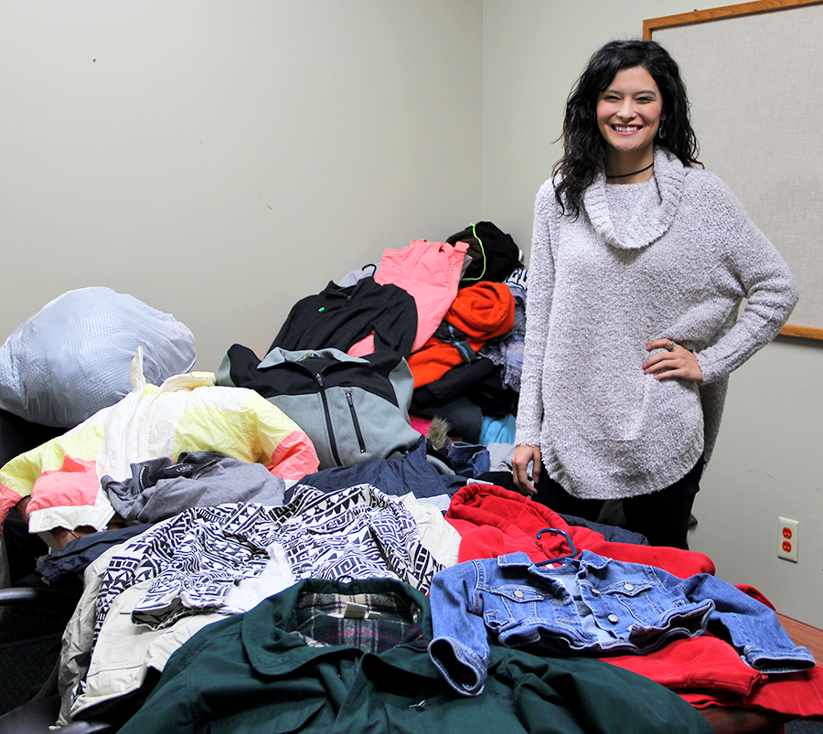 Student Government Association President Ofelia Chavoya stands with a portion of the donations that have been collected for Hunter's Helping Hoodies.