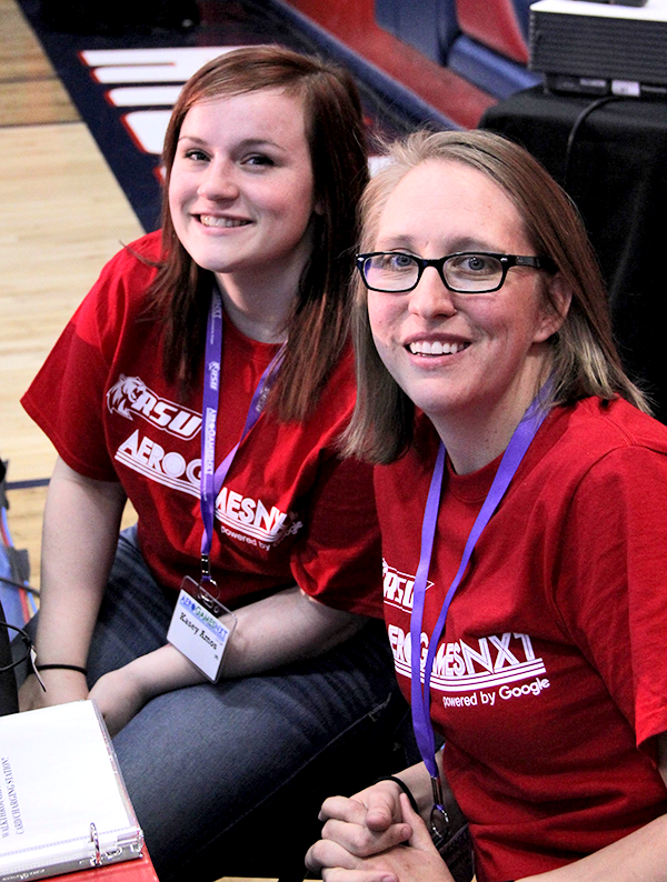 From left to right: AeroCats Kasey Amos and Brandi Cerrito manage a production table at the Aero Games. 