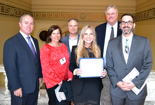 PHOTO CAPTION: Rogers State University student Lucy Redmon, a medical/molecular biology senior from Jenks, recently won first place at Research Day at the Capitol, a statewide competition highlighting undergraduate research at Oklahoma’s colleges and universities. Pictured at her awards presentation are, from left: Sen. Marty Quinn, her parents Tamara and John Redmon, Redmon, Rep. Mark Lepak, and Dr. Jim Ford, RSU Director of Academic Enrichment. 