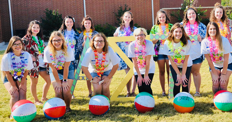 girls posing with letters and beach balls