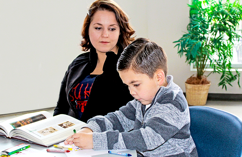 Chantel studying while her son colors