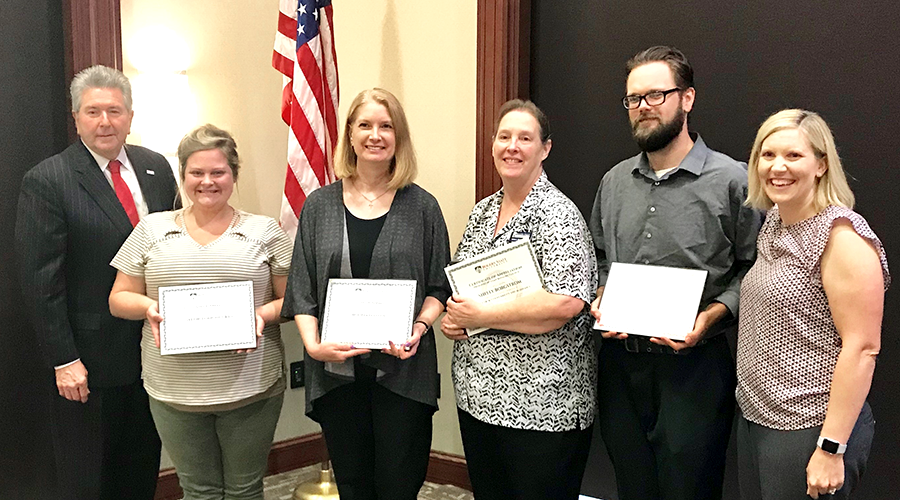Staff holding awards