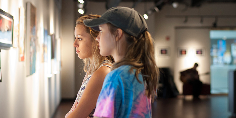 girls looking at art on the wall