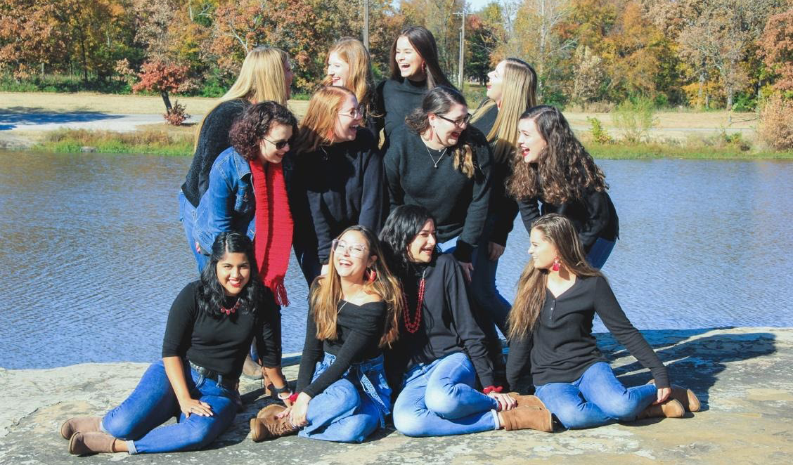 group of girls posing by lake