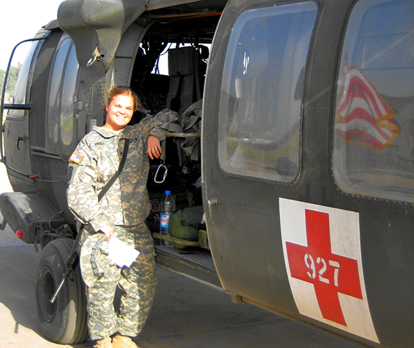 girl in military clothes standing by helicopter
