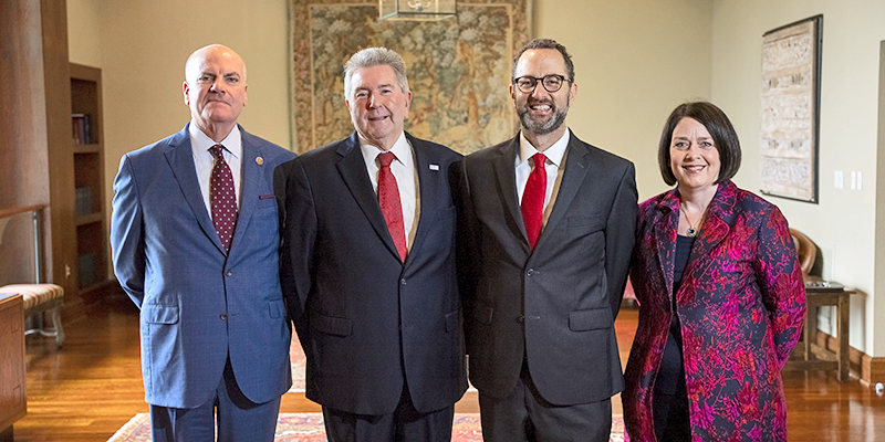 3 men and 1 woman standing for photo