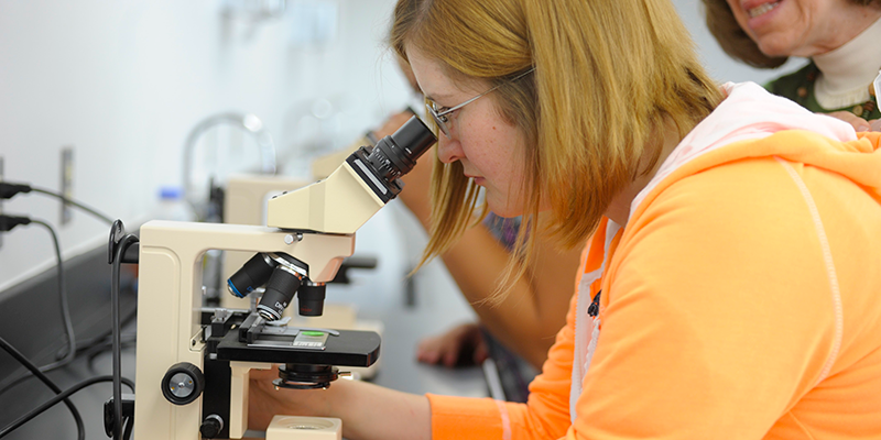 Girl looking into microscope