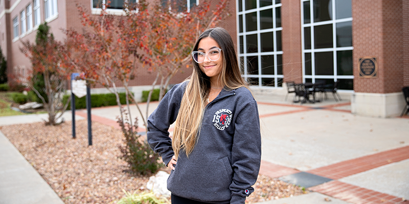 girl in glasses outside building