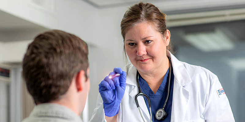 student nurse checking patient eyes