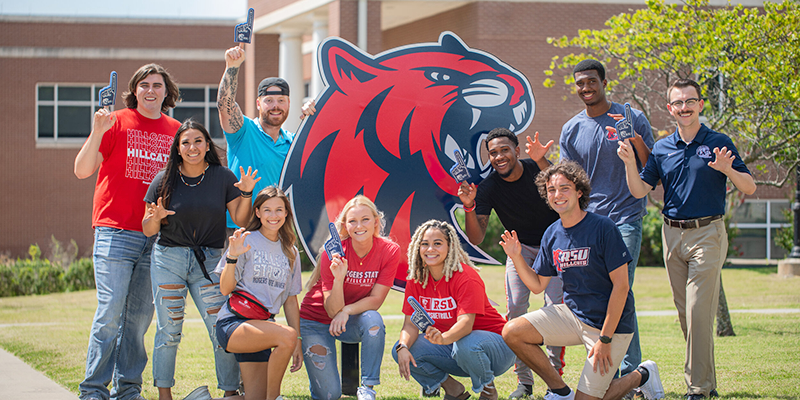 Students posing with large cat head