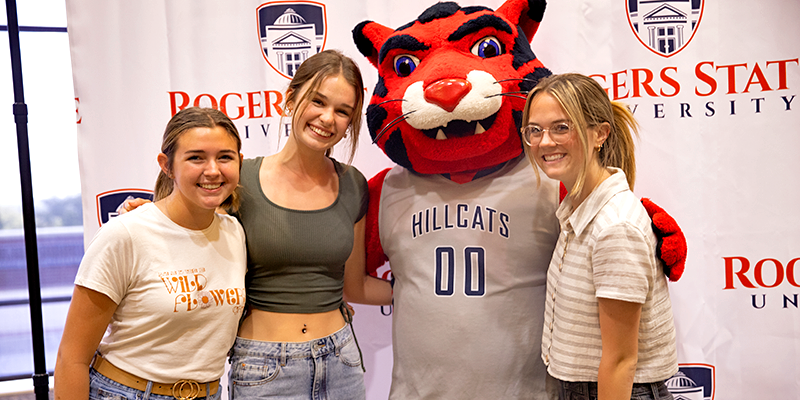 girls posing with hillcat mascot