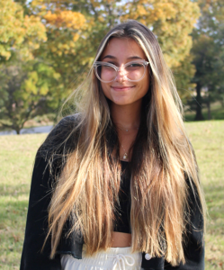 girl with long hair and glasses smiling