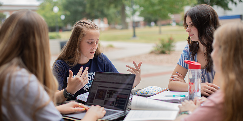 group of girls studying on patio
