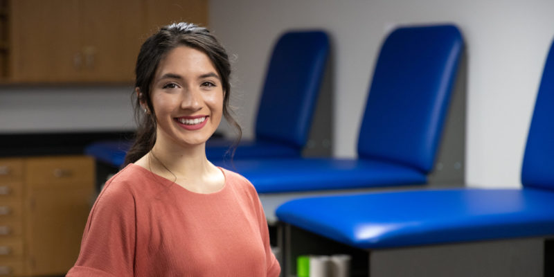 girl standing with chairs in background